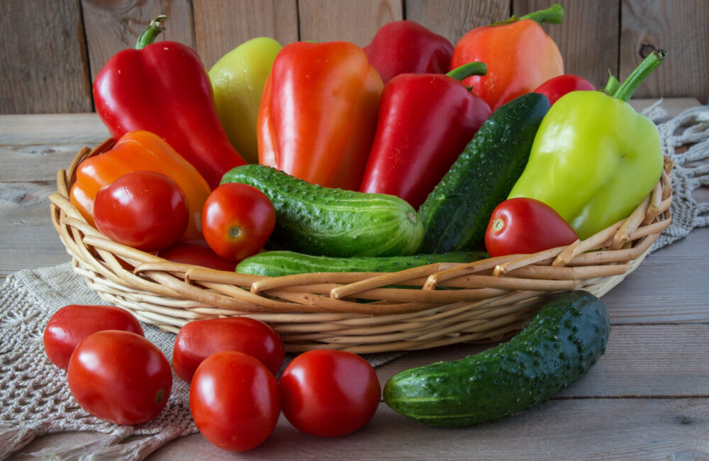 cucumbers,  tomatoes and sweet peppers in a wooden basket
