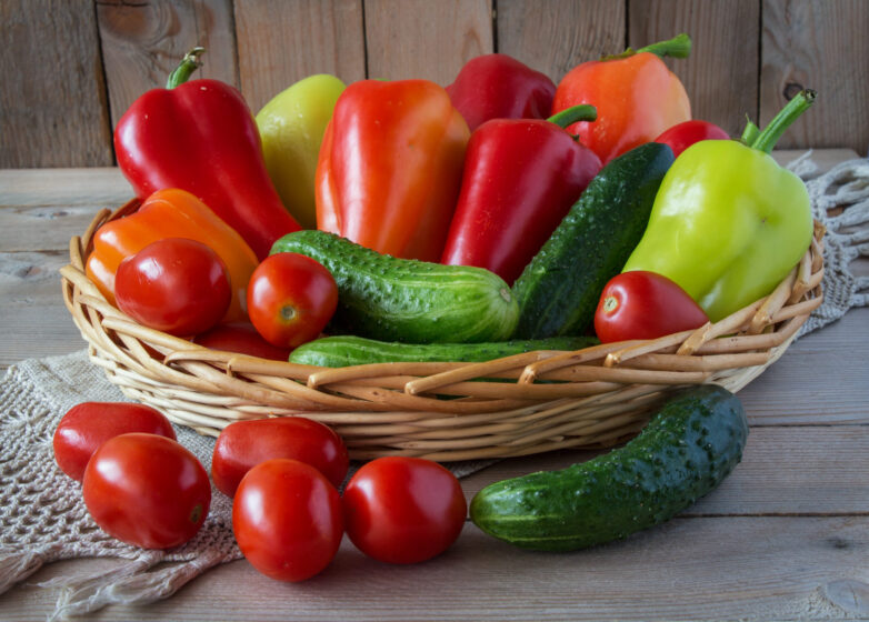 cucumbers,  tomatoes and sweet peppers in a wooden basket